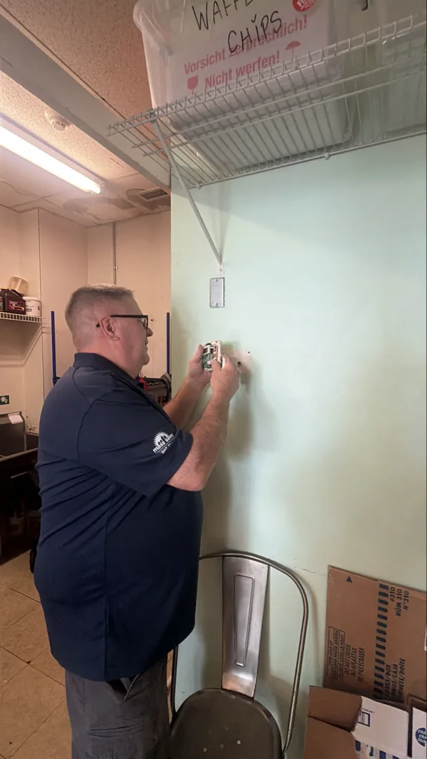 Advanced Ductless technician working on a wall control inside the shop.